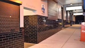 A reception area with a sign for Best Western, a mailbox, and a wall with a lockable storage unit. - Best Western Blackbutt Inn (New Lambton)