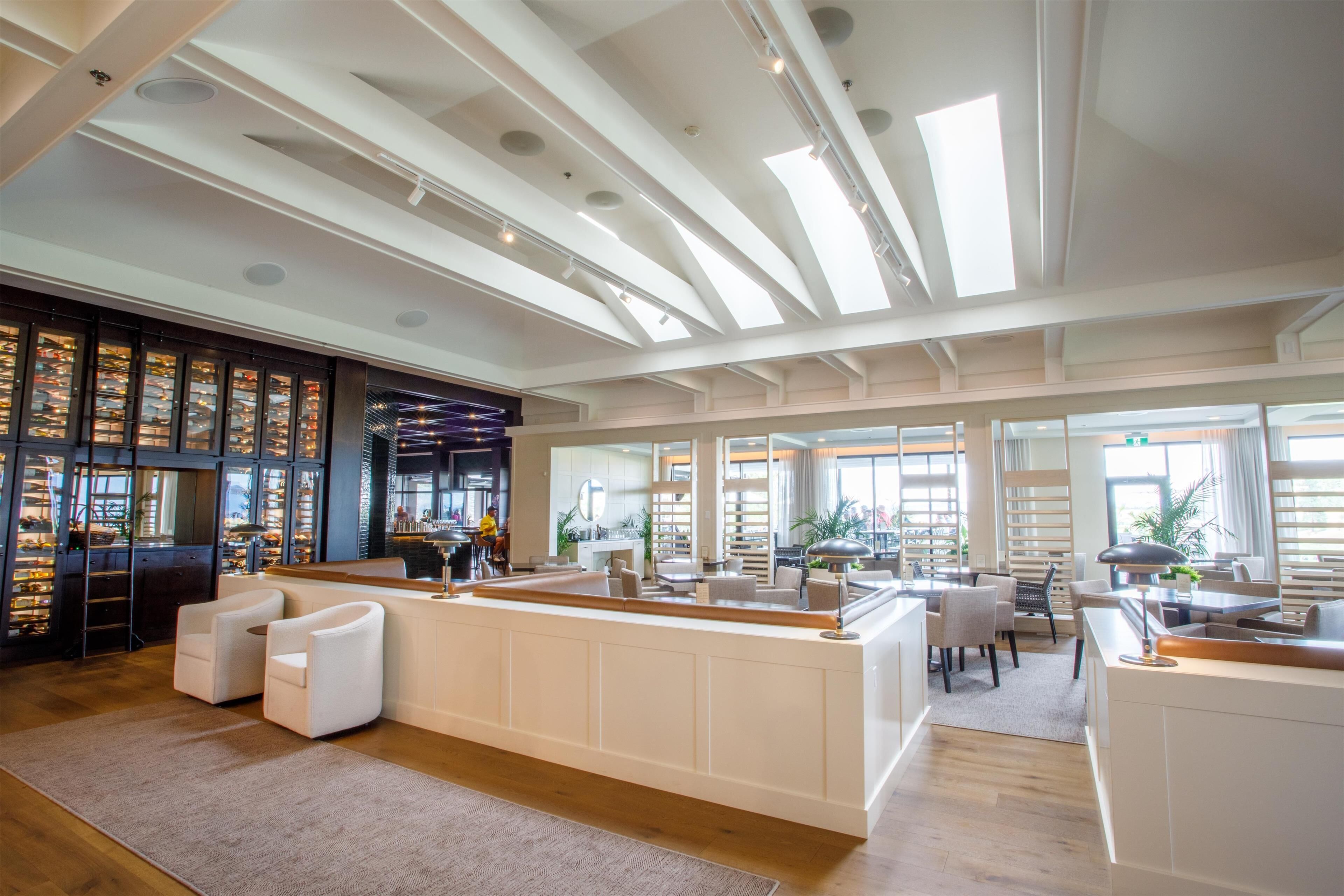 A spacious lobby with a central reception desk, seating area, and large windows allowing natural light.