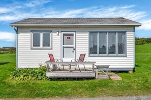 A small, single-story building with a porch, two windows, and a door. - Mavillette Beach Lodge and RV Park (Mavillette)