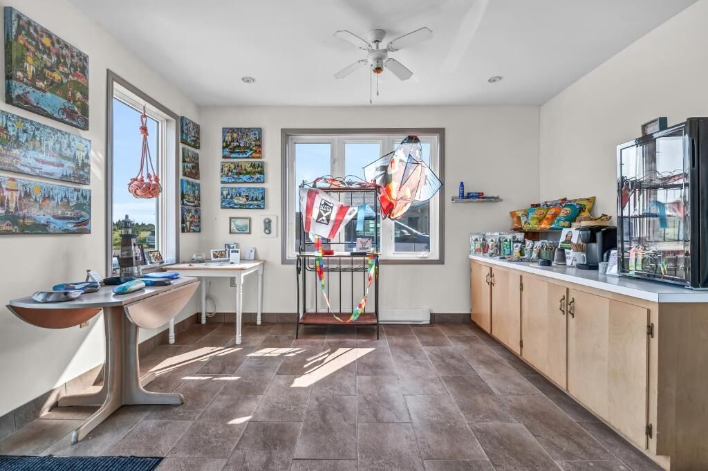 Una cocina con una mesa de comedor, un ventilador de techo y una ventana con vistas.