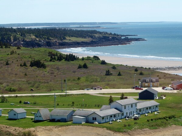 Une propriété située sur la côte, comprenant plusieurs bâtiments, une plage et une zone boisée.