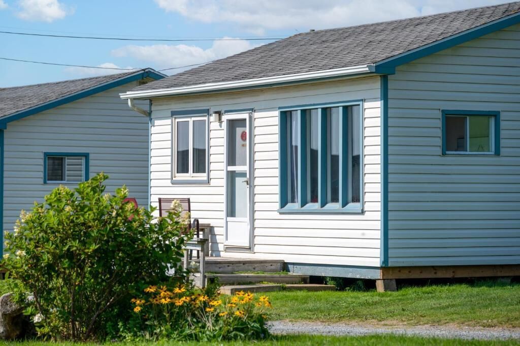 A single-story house with a front porch, a door, and windows.