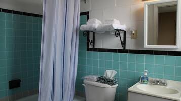 Un bagno con il water, un lavandino e uno specchio sopra il lavandino.