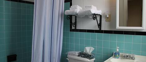 Un baño con inodoro, lavamanos y espejo sobre el lavamanos.