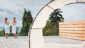 A rooftop terrace with two white lounge chairs and a wooden deck. - Parkhotel Schillerhain (Kirchheimbolanden)