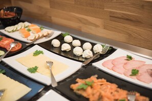 A buffet with various dishes including sushi, cheese, and meat. - Parkhotel Schillerhain (Kirchheimbolanden)