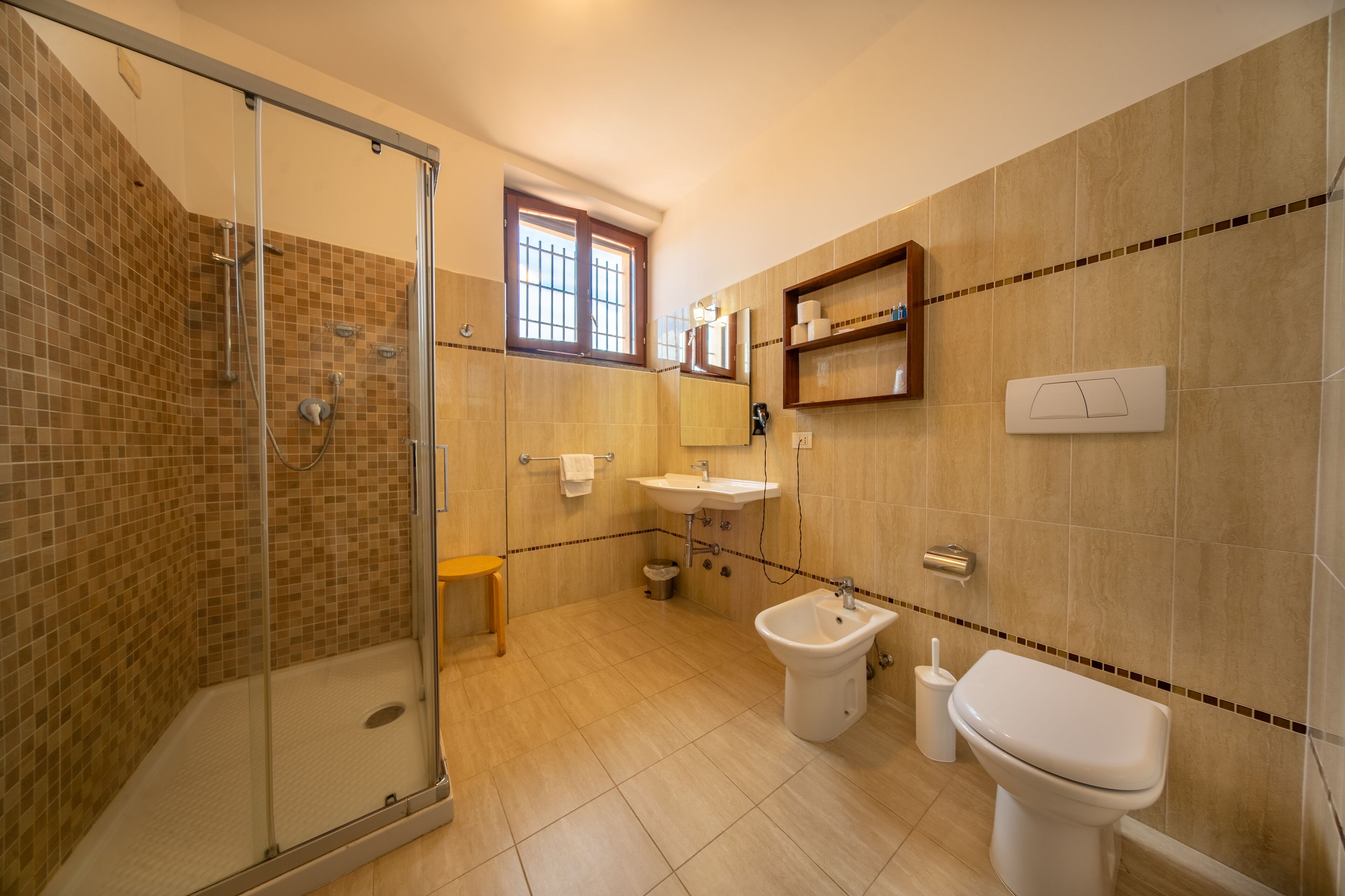 Un baño con ducha de vidrio, lavamanos, un bidé y un inodoro.