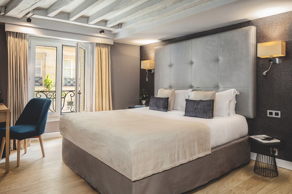 Um quarto espaçoso com uma cama grande, uma escrivaninha e uma cadeira.