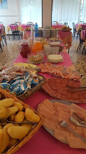 Una mesa de buffet con diversas opciones de comida y bebidas.