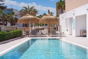 室外游泳池，提供日光浴躺椅和救生員