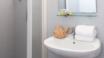 Un bagno con doccia, lavandino e specchio.