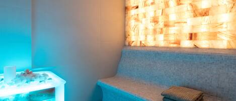 A spa area with a bench and a heated stone wall.