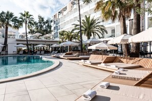 A poolside area with lounge chairs, umbrellas, and a swimming pool. - Bordoy Alcudia Port Suites - Adult Only (Alcúdia)