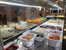 Buffet com diversos alimentos e utensílios.