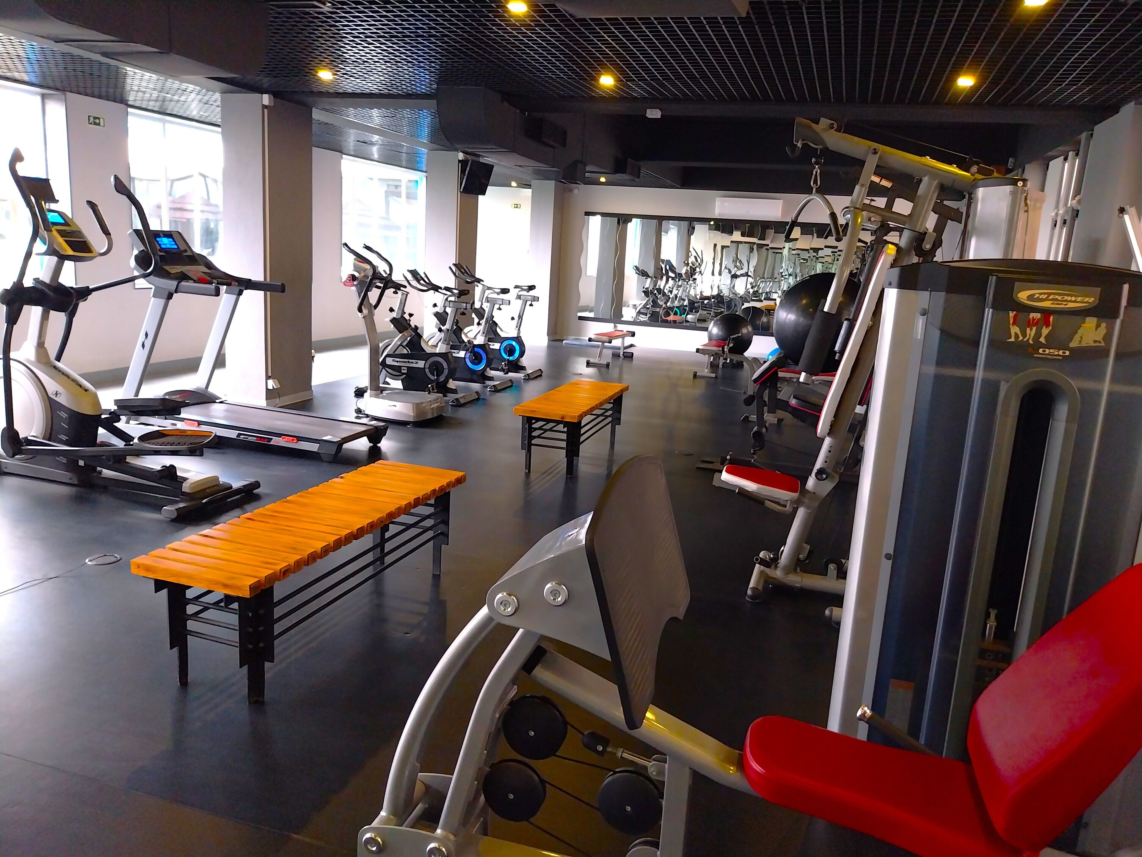 A gym with various exercise equipment, including treadmills, stationary bikes, and weight machines.