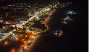 An aerial view of a coastal city at night with illuminated streets, buildings, and a beach area. - Hotel Navegadores (Vila Real Santo Antonio)