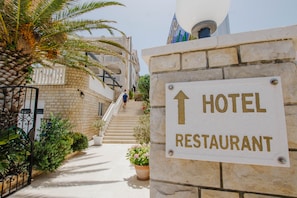 Señal de hotel y restaurante con una escalera que conduce a un edificio.