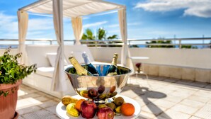 A table with a fruit bowl, champagne bottles, and a white canopy. - Apartamentos Oro Blanco (Arona)