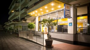 A hotel entrance with a covered outdoor area, potted plants, and a sign indicating the name 'Apartamentos Oro Blanco'. - Apartamentos Oro Blanco (Arona)