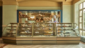 Una vetrina di pasticceria con diversi dolci e pane.
