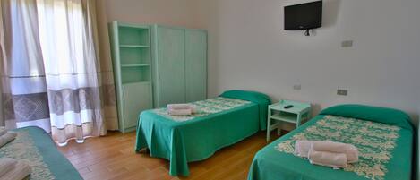 A room with two beds, a TV, and a wardrobe.