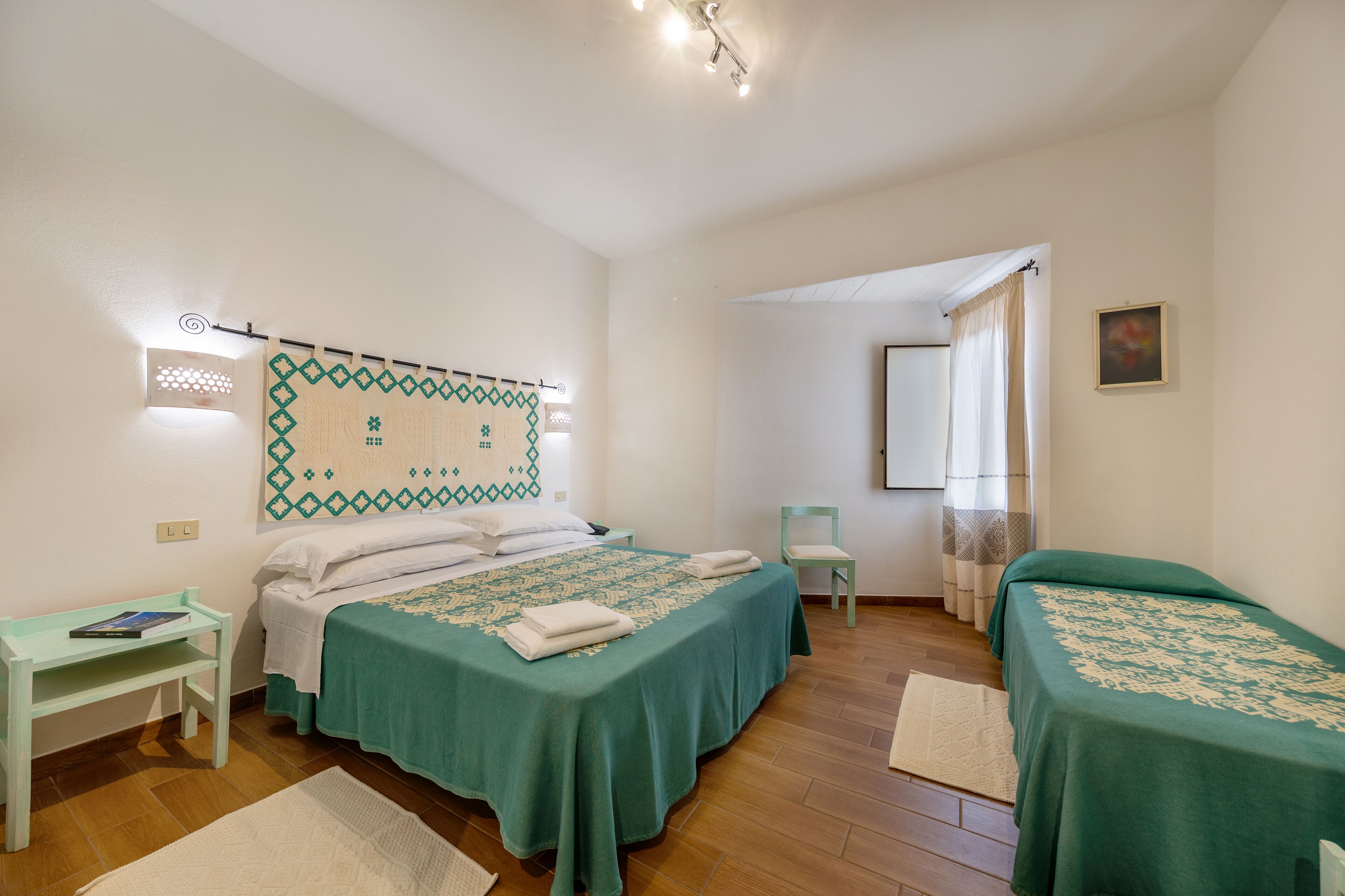 Een slaapkamer met twee enkele bedden, een klein bureau en een stoel.