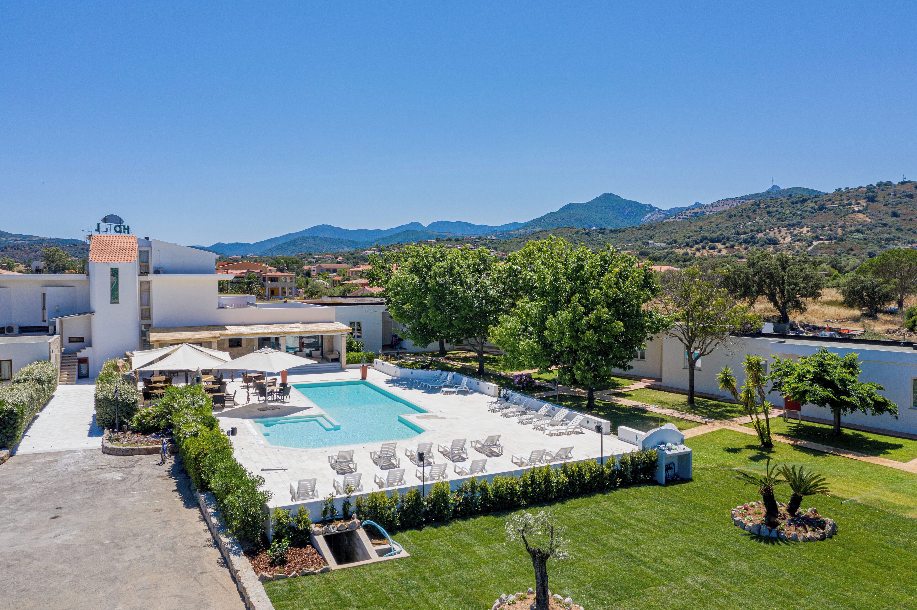 Un hôtel doté d’une piscine, de chaises longues et offrant une vue sur le paysage environnant.