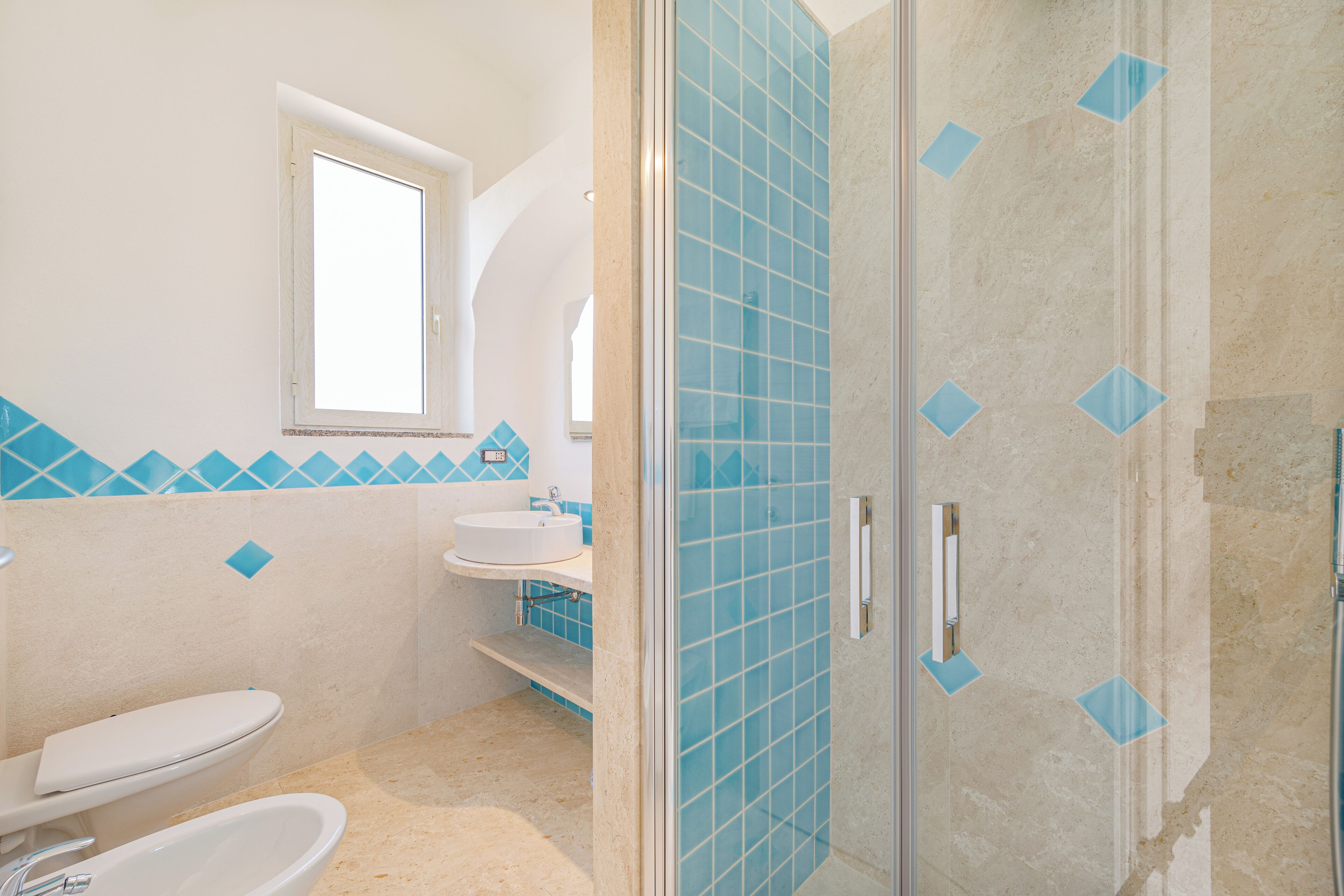 A bathroom with a toilet, sink, and shower.