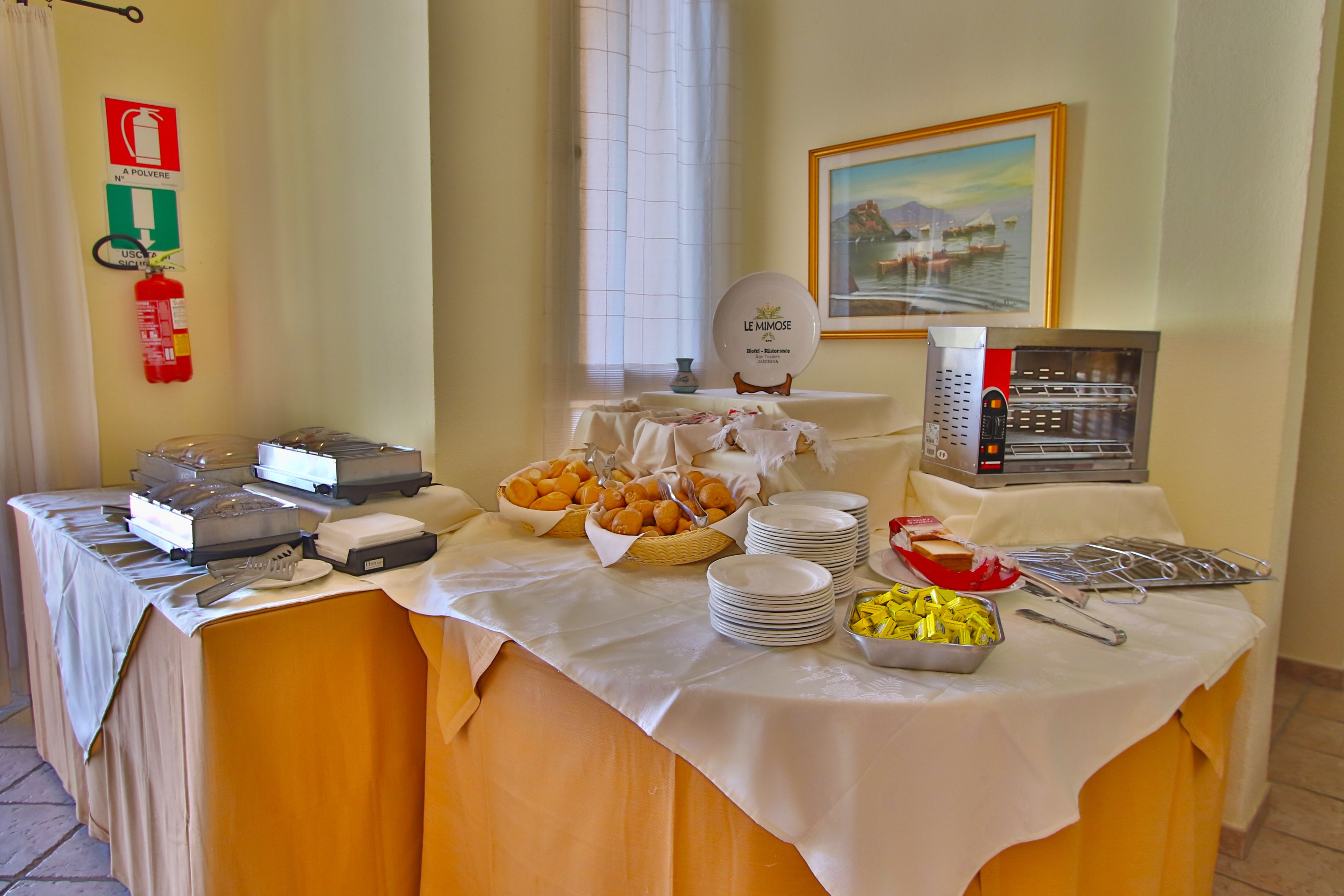 A buffet table with various food items and a coffee machine.