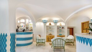 Ein geräumiges Zimmer mit Bar, Sitzgelegenheiten und einem Holzkabinett.