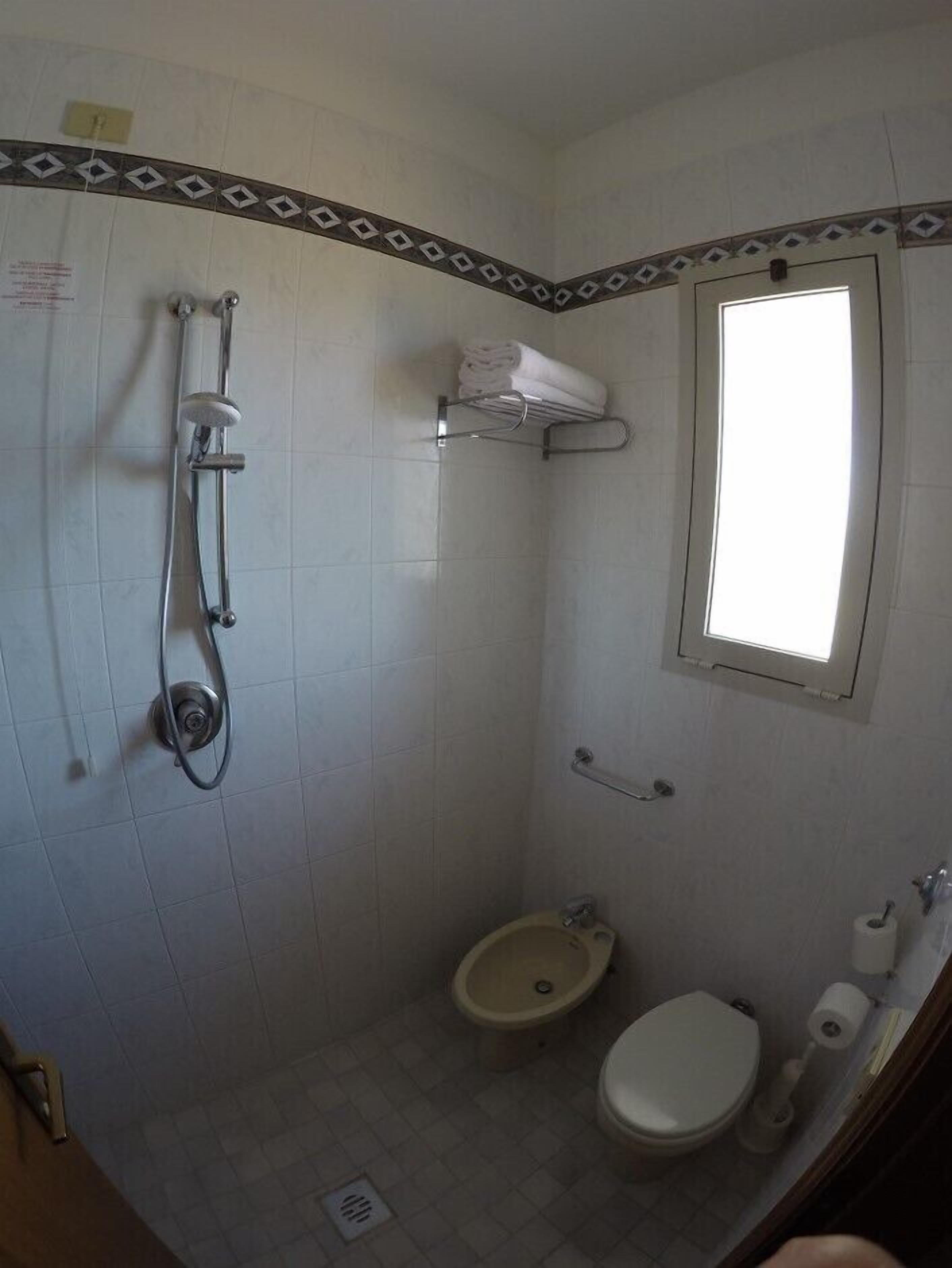 Ein kleines Badezimmer mit Dusche, Toilette und Waschbecken.