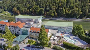 Ein Hotel mit mehreren Gebäuden, einem Swimmingpool und einem Fluss im Hintergrund.