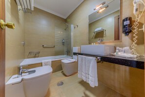 A modern bathroom with a bathtub, toilet, and sink. - Hotel Playa De Regla (Chipiona)