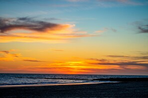 A sunset over the ocean with a clear sky and calm waters. - Hotel Playa De Regla (Chipiona)