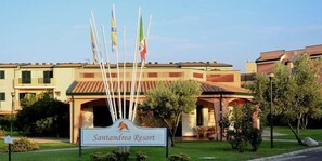 A sign for Santanderia Resort with a clear view of the building's entrance and surrounding greenery. - Villaggio Santandrea Resort (Sant'Andrea Apostolo dello Ionio)