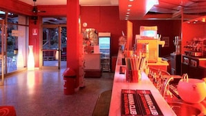 Un intérieur moderne aux couleurs dominantes rouges, avec un comptoir d'accueil et un présentoir pour les supports promotionnels.