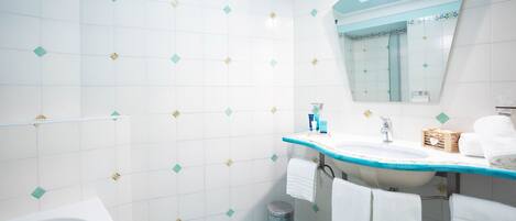A bathroom with a white sink, a mirror, and a bathtub.
