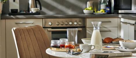 A breakfast tray with food and drinks on a table in a modern kitchen.