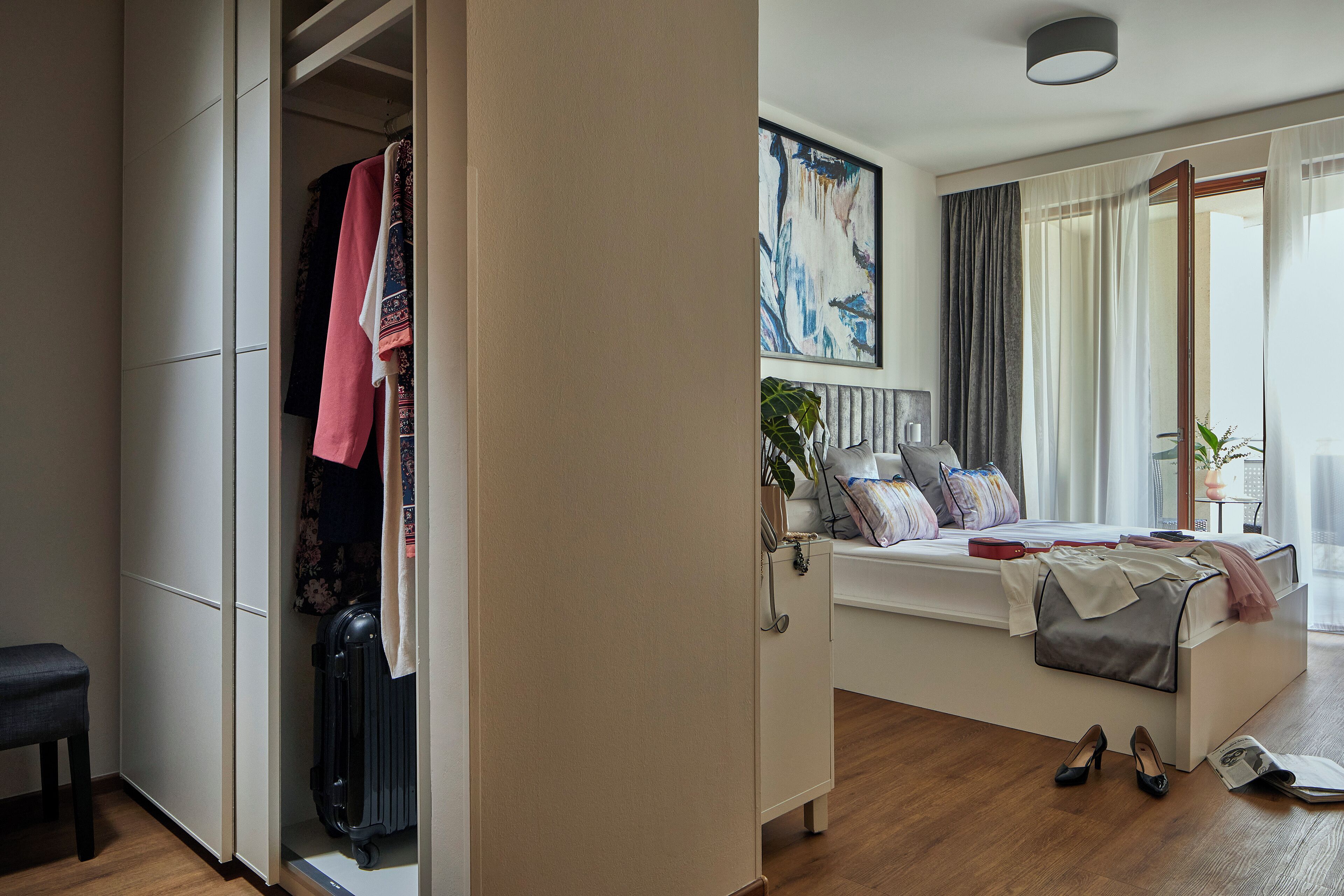 Une chambre d’hôtel moderne, équipée d’un lit, d’une table de chevet et offrant une vue sur l’extérieur.