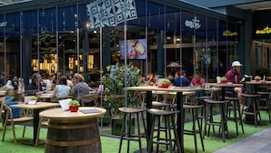 An indoor dining area with tables and chairs, a glass storefront, and a sign that reads "antre."