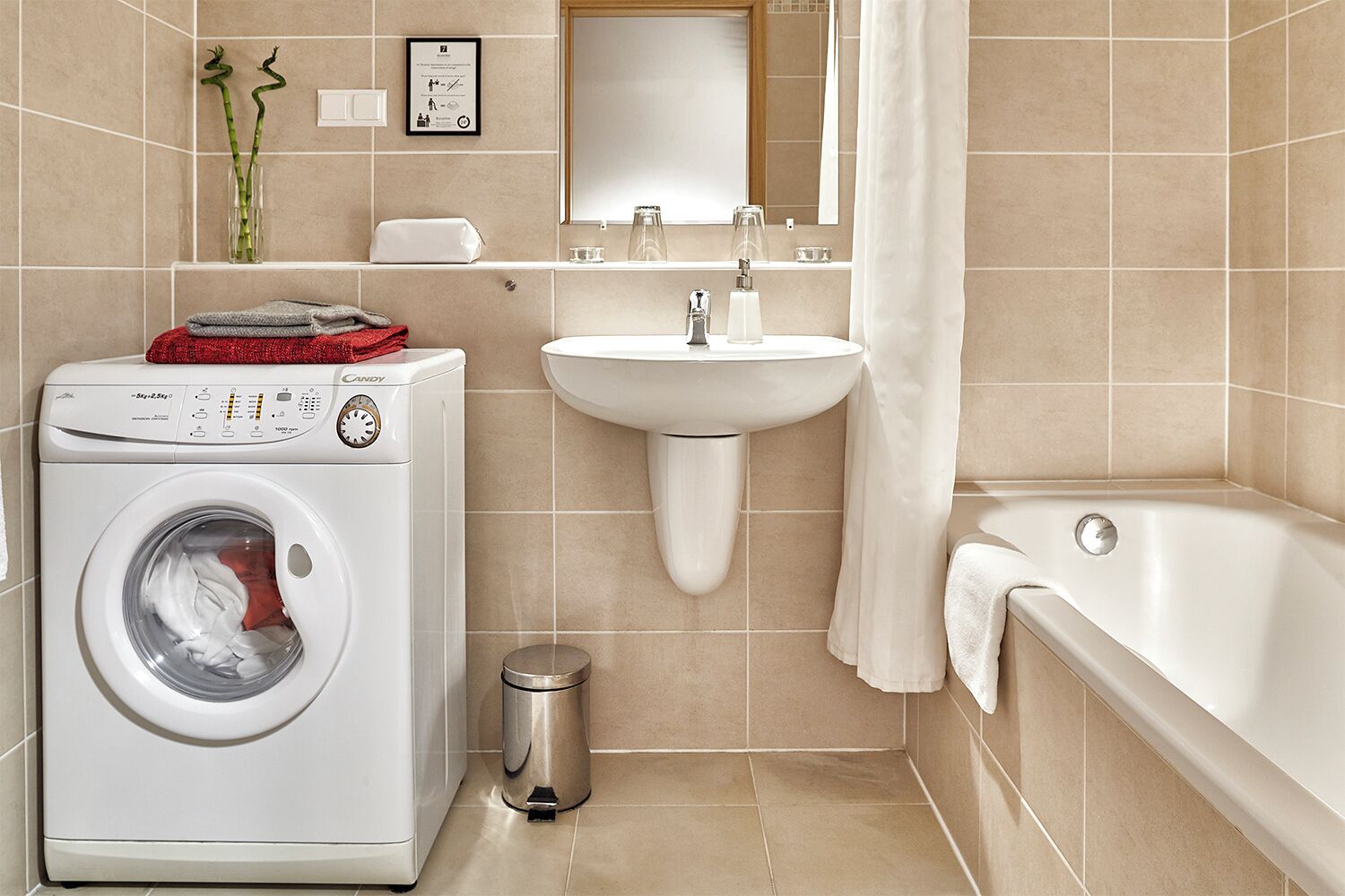Une salle de bain moderne équipée d’un lave-linge, d’un lavabo et d’une baignoire.