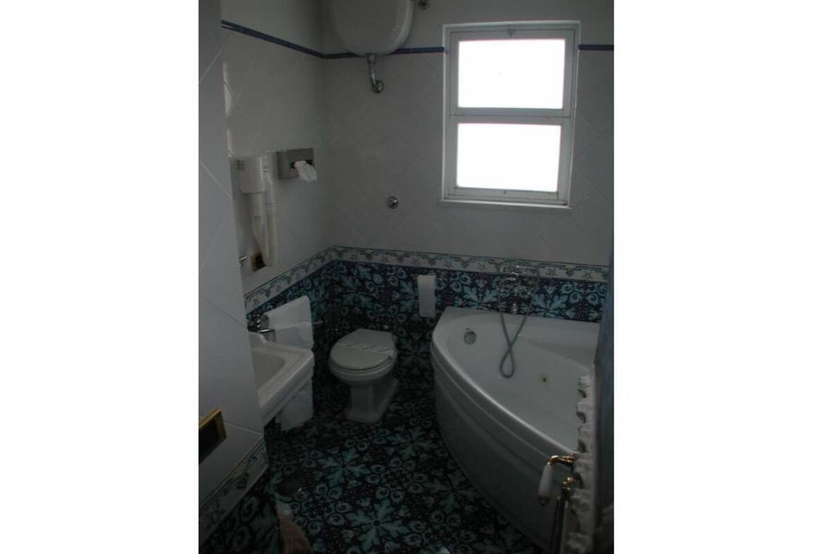A bathroom with a toilet, sink, and bathtub.