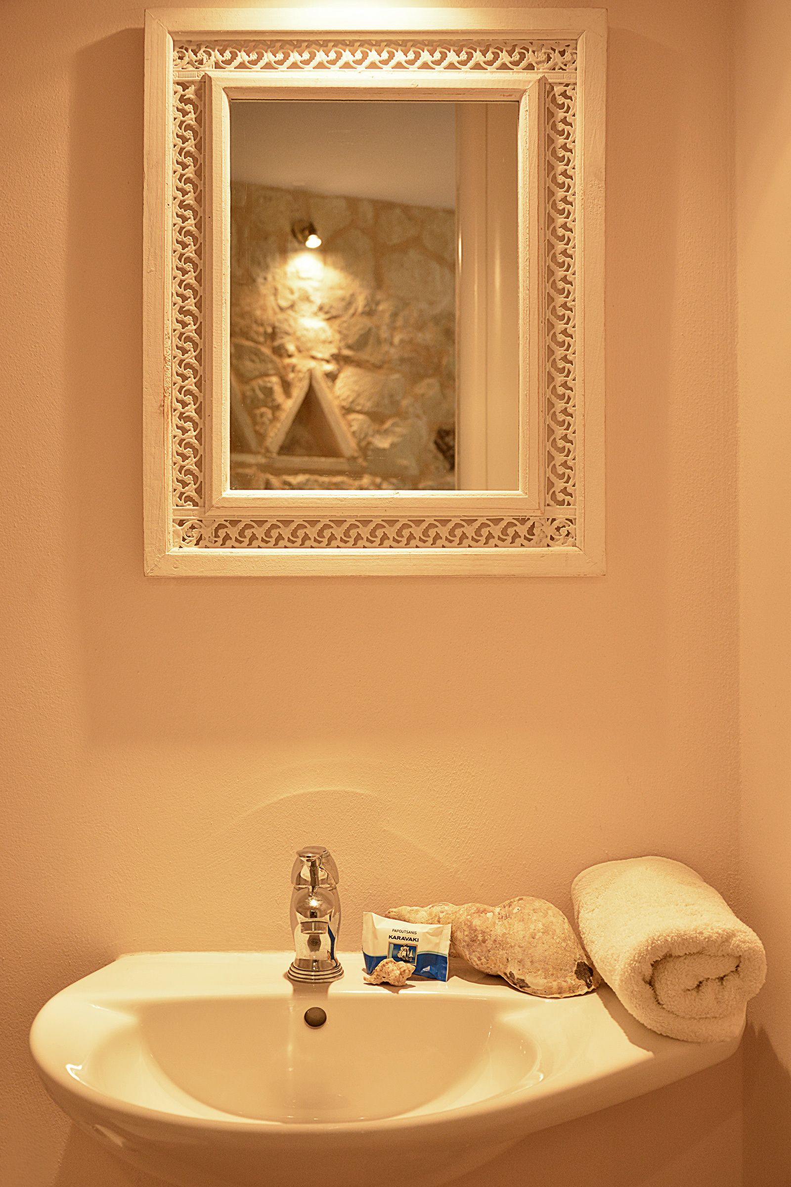 A bathroom with a sink, mirror, and towel.
