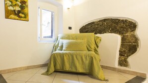 Une pièce comprenant un lit, une fenêtre, un tableau et un décor mural original.