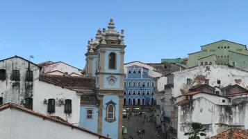 Une rue historique, avec un clocher d’église imposant et des bâtiments aux couleurs vives.