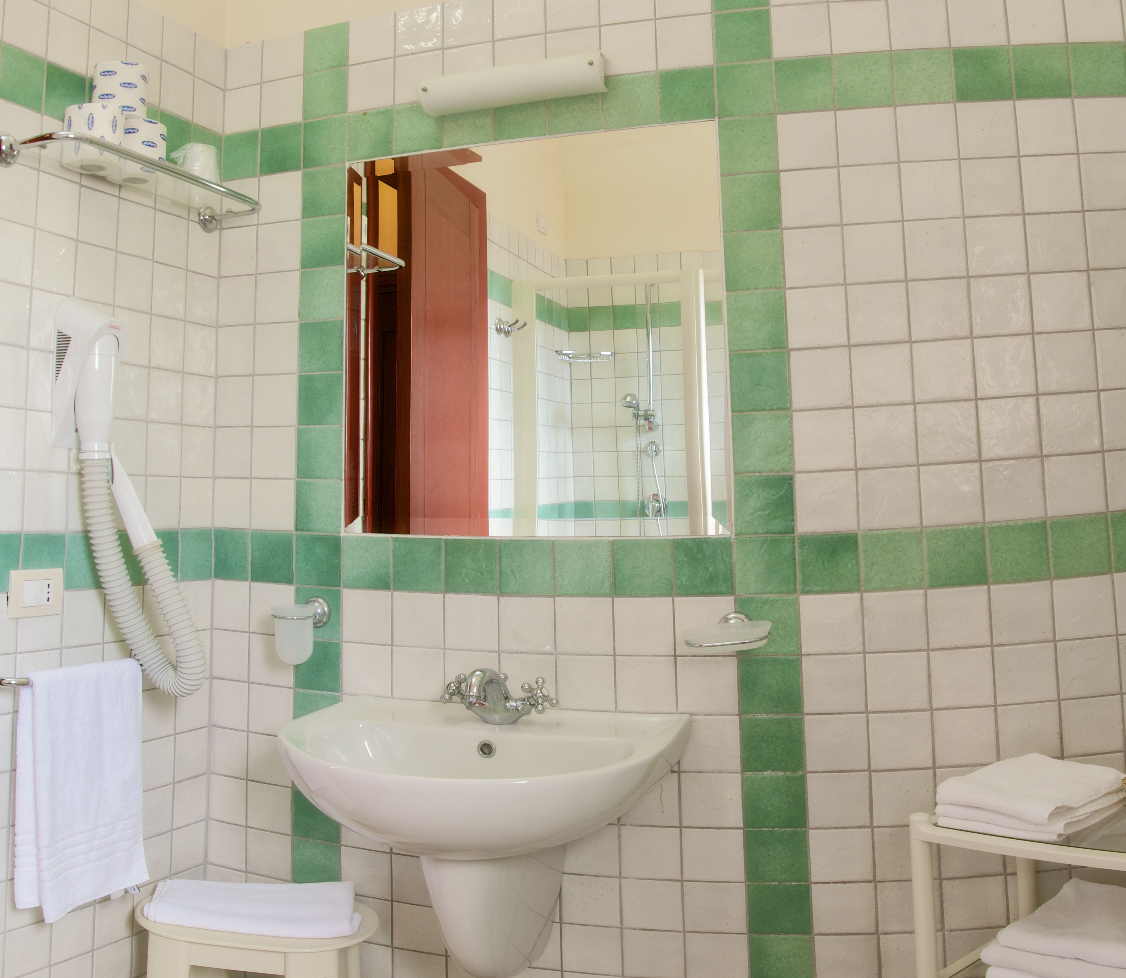 A bathroom with a sink, mirror, and towel rack.