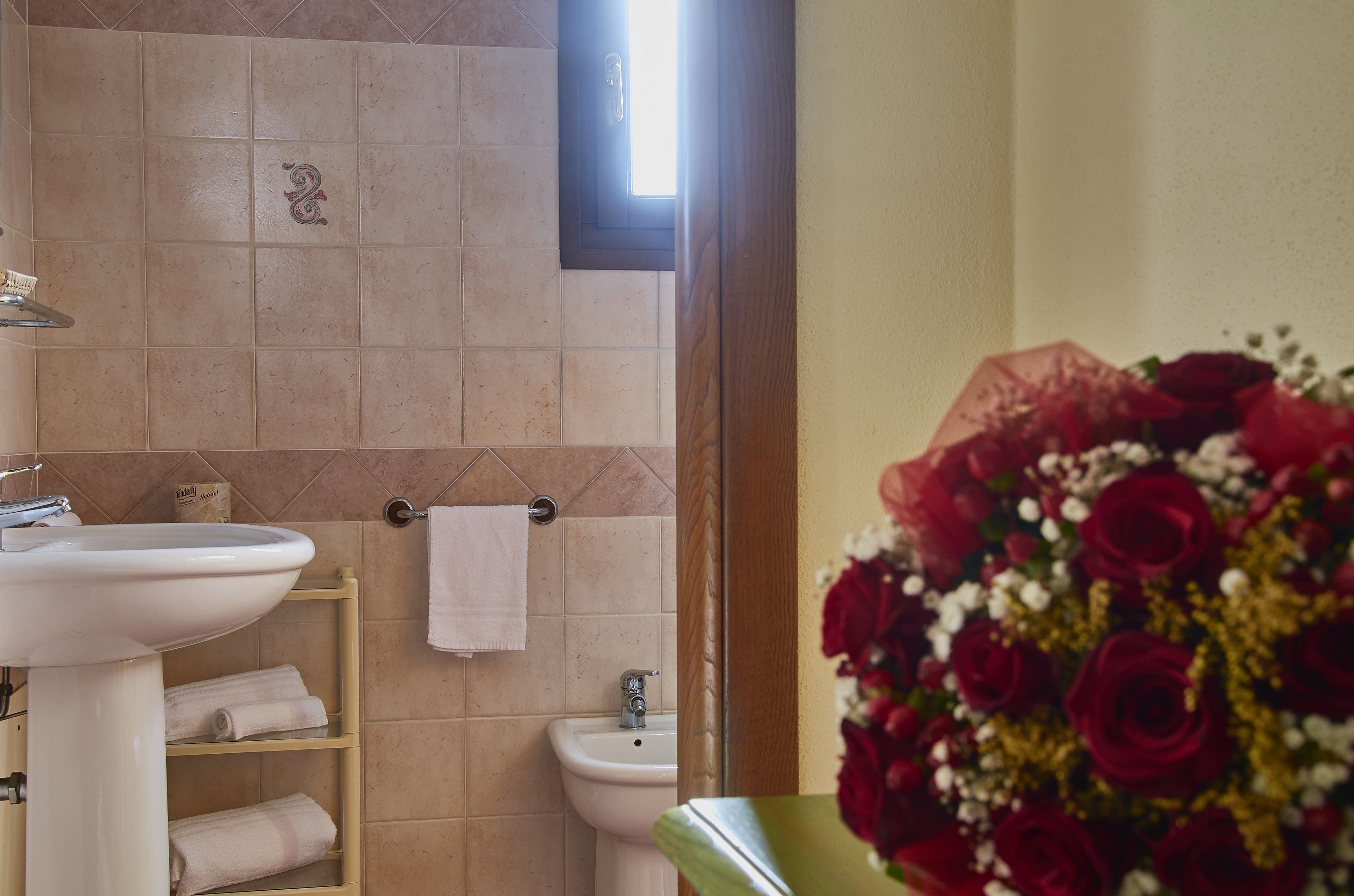 Un baño con lavamanos, bidé y toallero.