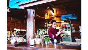 Zona de bar amb parets de fusta, televisió penjada a la paret i diverses ampolles i vasos sobre prestatgeries.