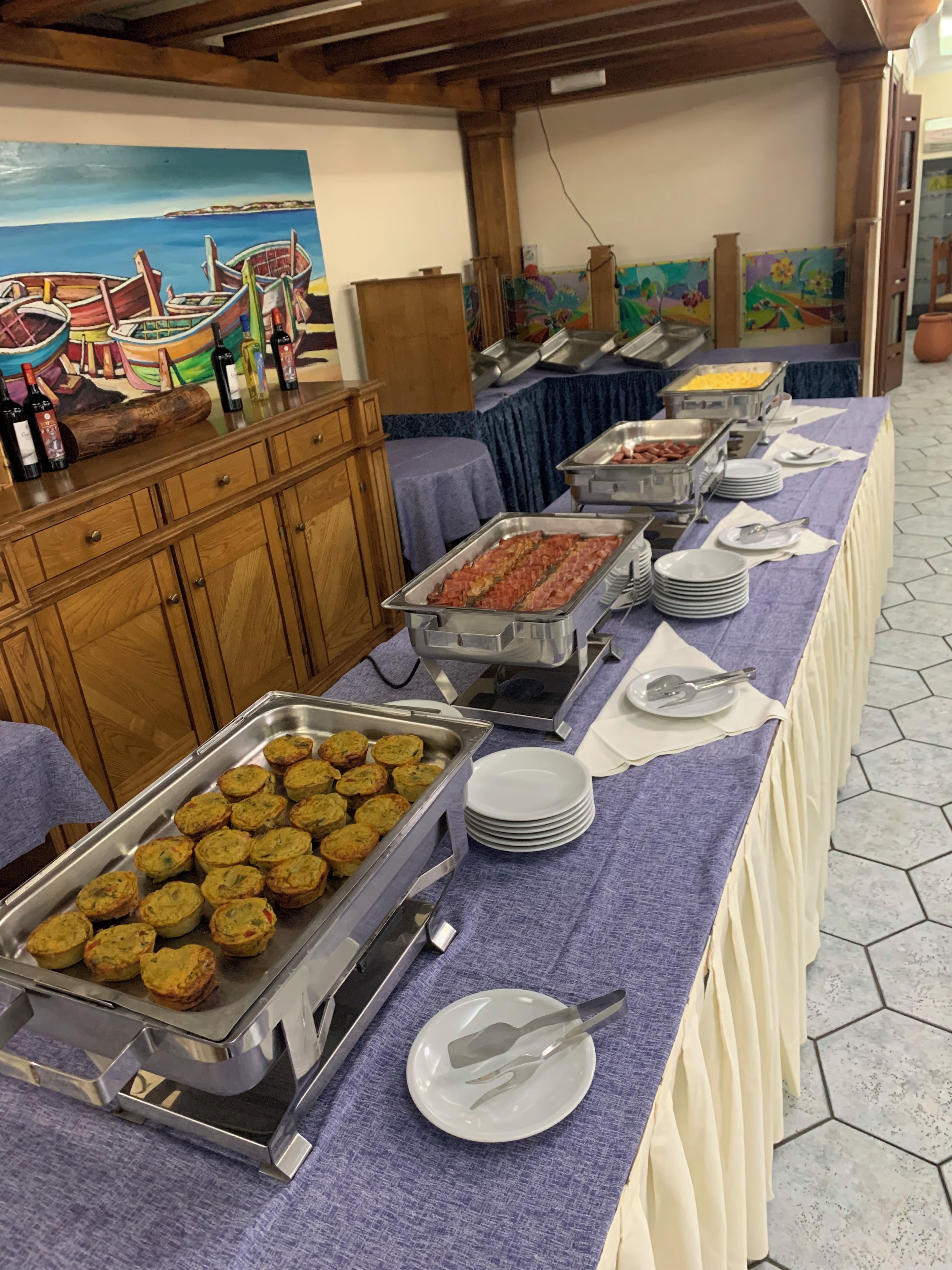A buffet setup with various food items and utensils.