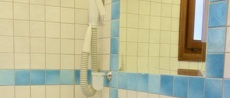 Ein Badezimmer mit einem weißen Waschbecken, einem Spiegel und einem Handtuchhalter.